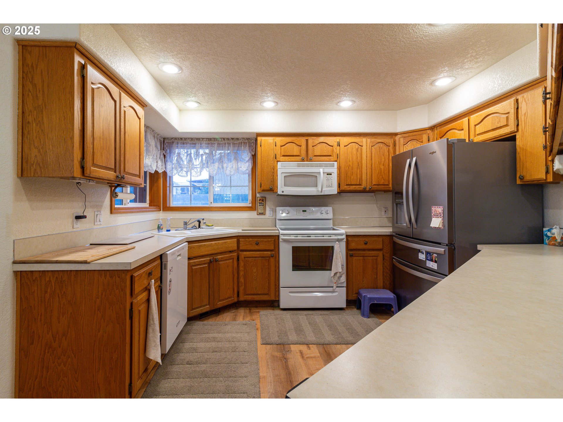 305 Northwest 9th Place Hermiston, OR 97838 - Photo 31 of 31 a kitchen with stainless steel appliances kitchen island granite countertop a sink stove and refrigerator