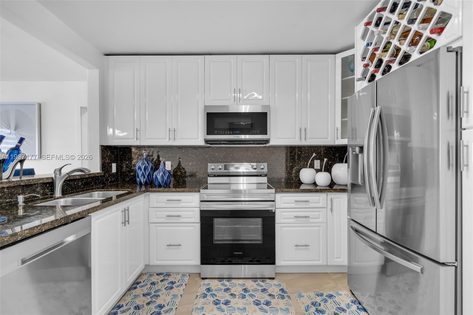 3130 Northwest 102nd Street Miami, FL 33147 - Photo 11 of 42 a kitchen with stainless steel appliances granite countertop a refrigerator sink stove and white cabinets