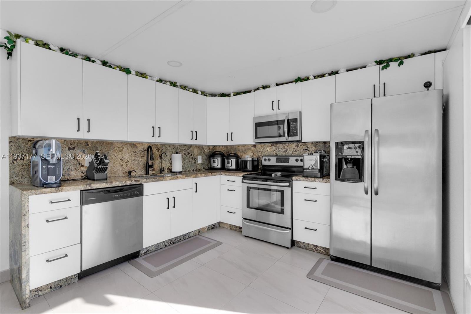 3130 Northwest 102nd Street Miami, FL 33147 - Photo 29 of 42 a kitchen with white cabinets and white appliances