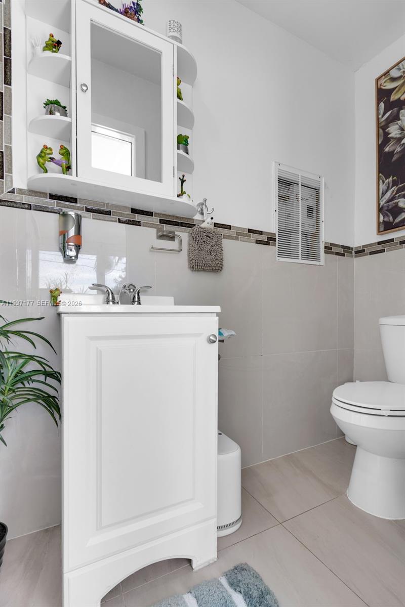 3130 Northwest 102nd Street Miami, FL 33147 - Photo 30 of 42 a bathroom with a sink a toilet and mirror