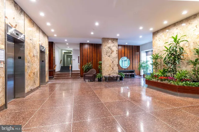 a lobby with furniture and potted plants