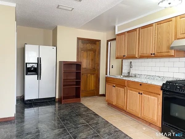 a kitchen with stainless steel appliances granite countertop a refrigerator and a stove top oven