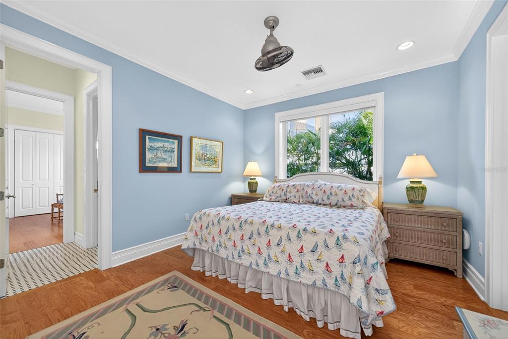 7152 Point Of Rocks Circle Sarasota, FL 34242 - Photo 59 of 88 a bedroom with a bed and a lamp on dresser with wooden floor