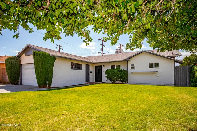a front view of house with yard and garage