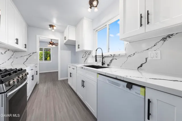a kitchen with white cabinets and appliances