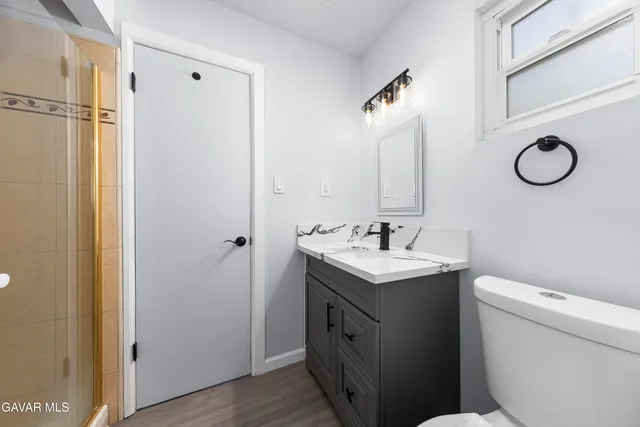 a bathroom with a granite countertop sink toilet and shower
