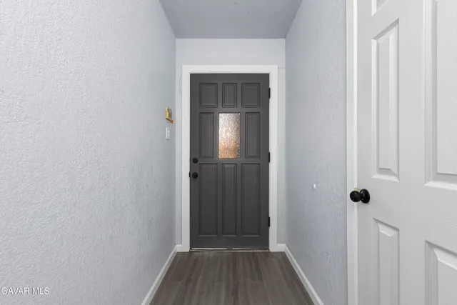 a view of a hallway with wooden floor and entryway