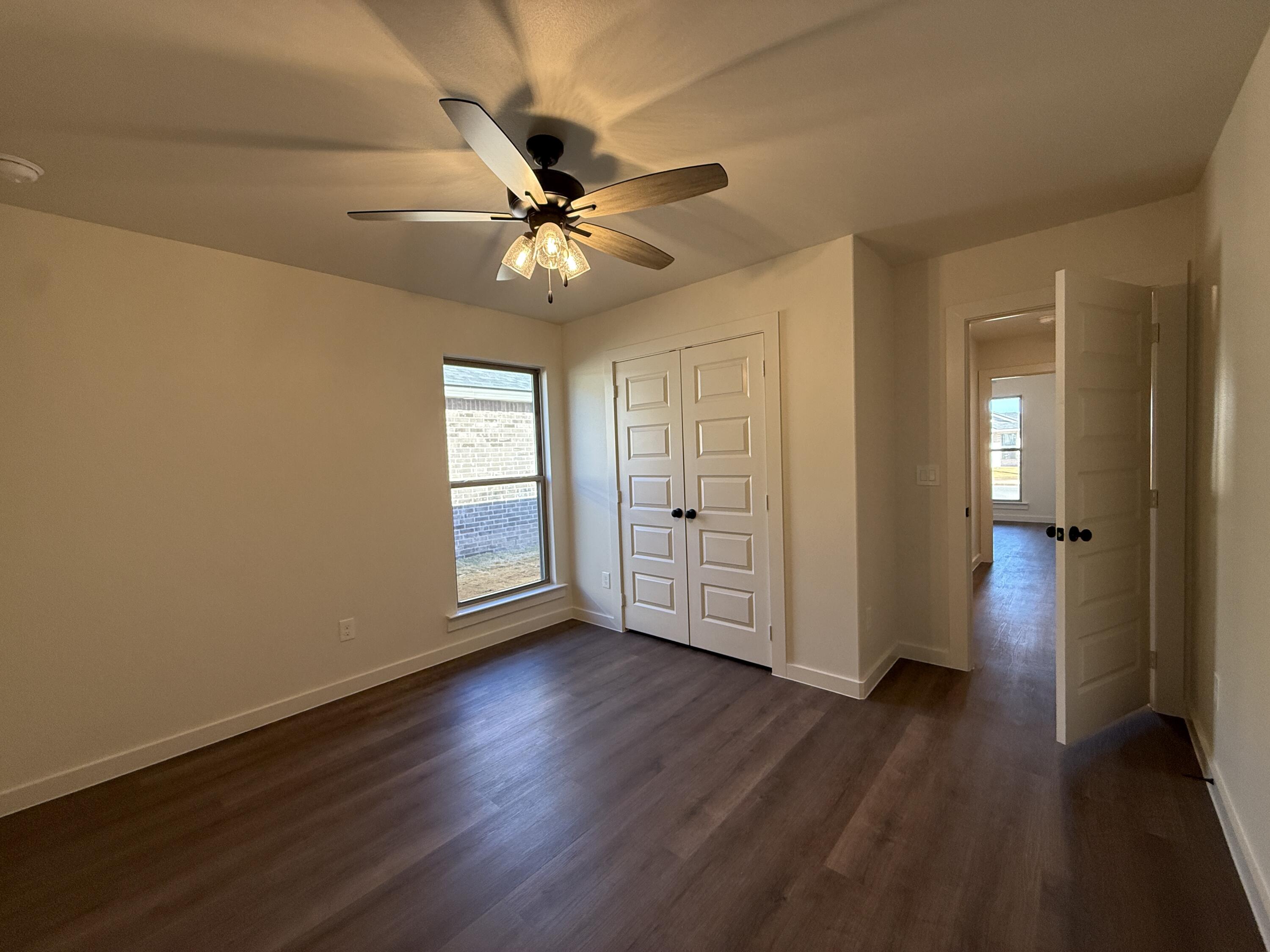 3015 138th Place Lubbock, TX 79423 - Photo 11 of 13 an empty room with wooden floor fan and windows