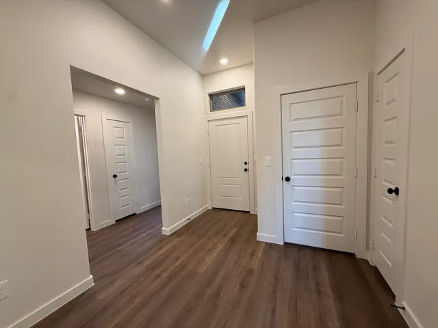 a kitchen with a sink dishwasher a dining table and chairs with wooden floor