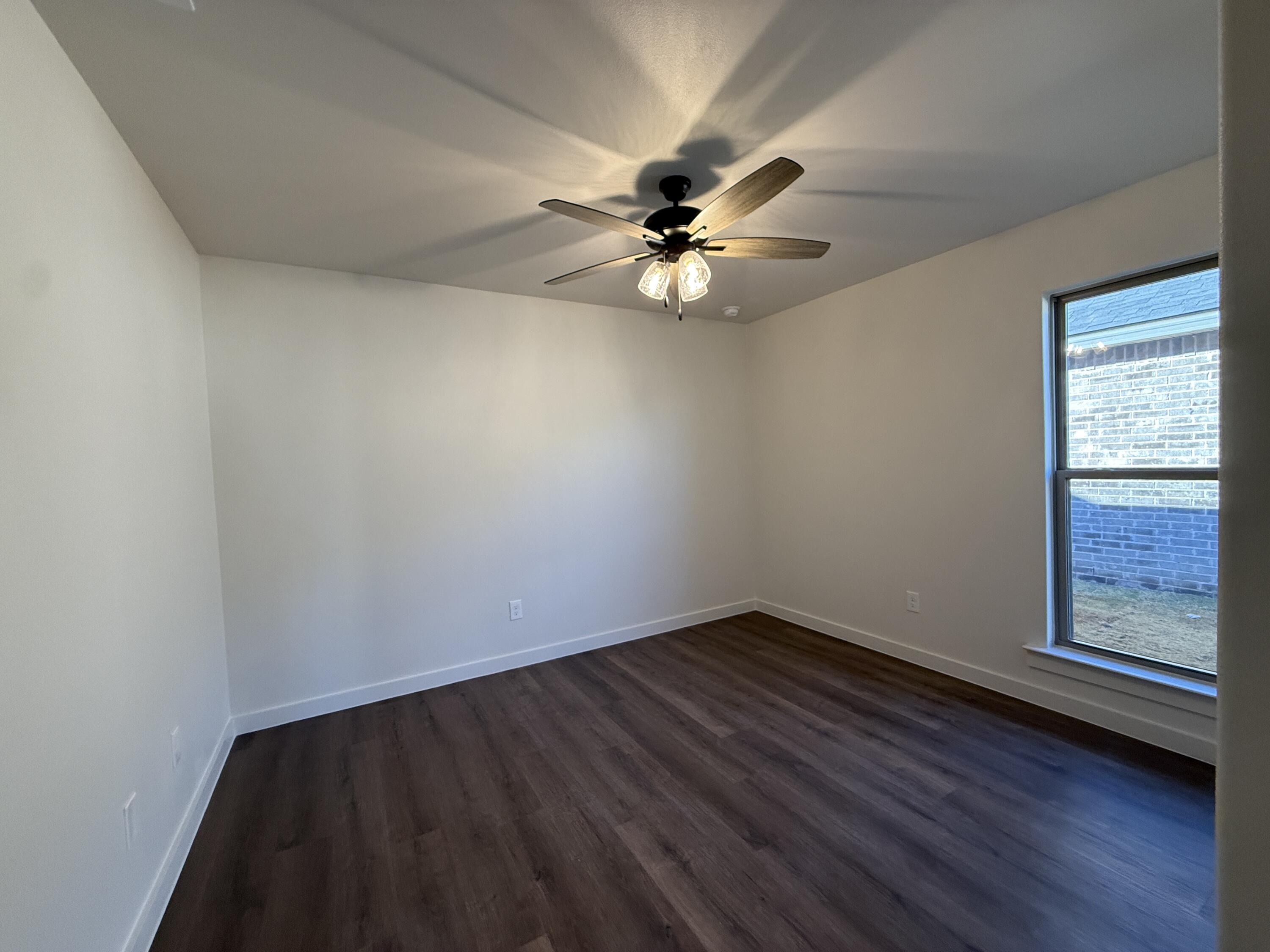 3015 138th Place Lubbock, TX 79423 - Photo 9 of 13 a view of empty room with wooden floor and fan