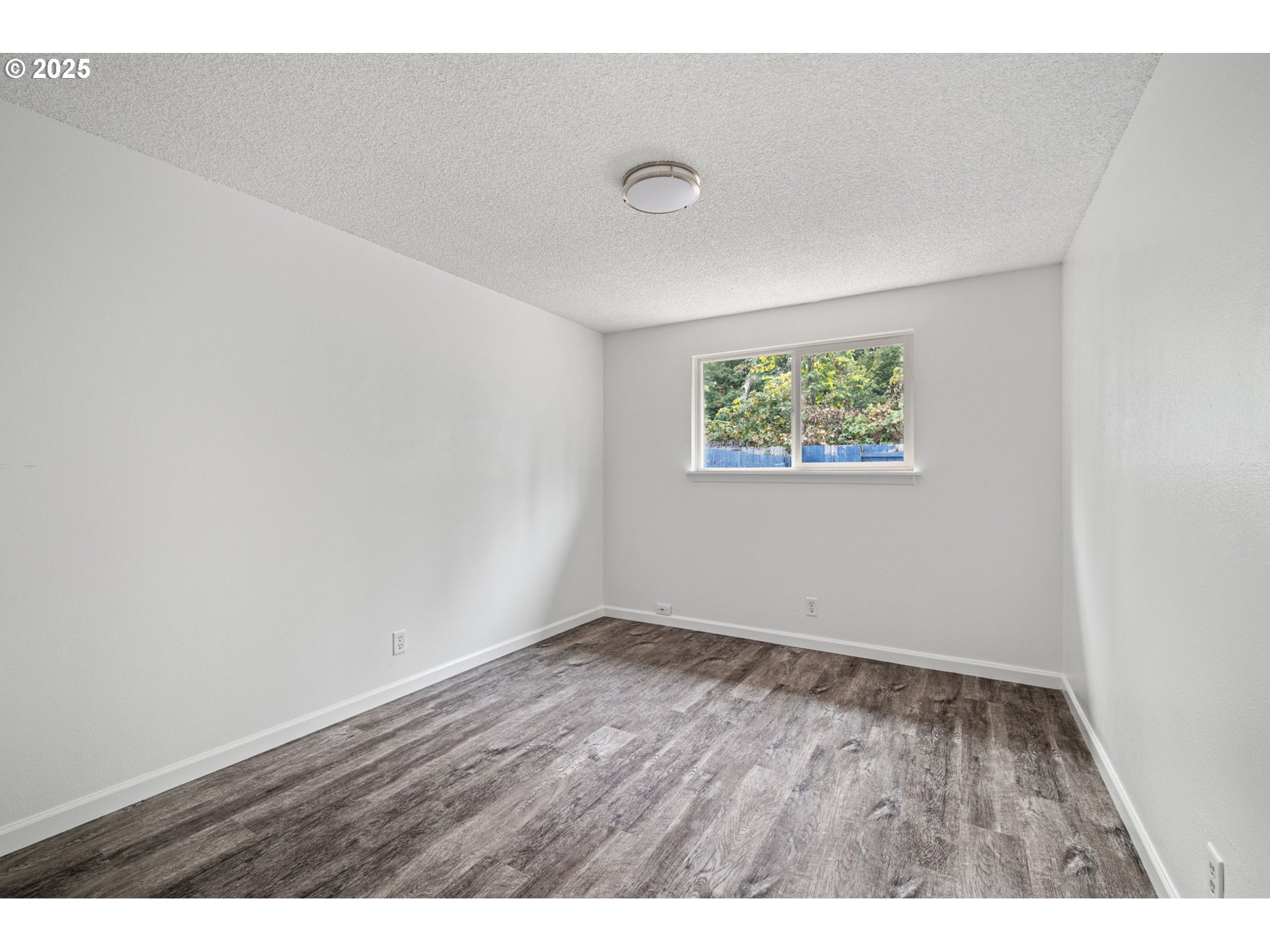 4883 Elderberry Loop Springfield, OR 97478 - Photo 16 of 23 an empty room with wooden floor and windows