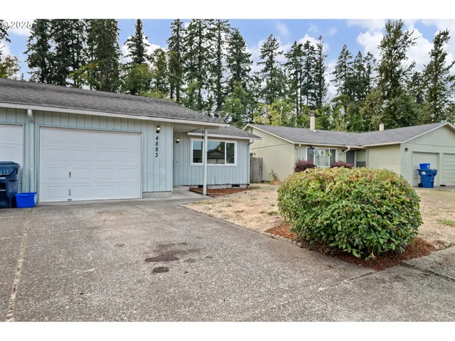 a view of a house with a backyard and trees