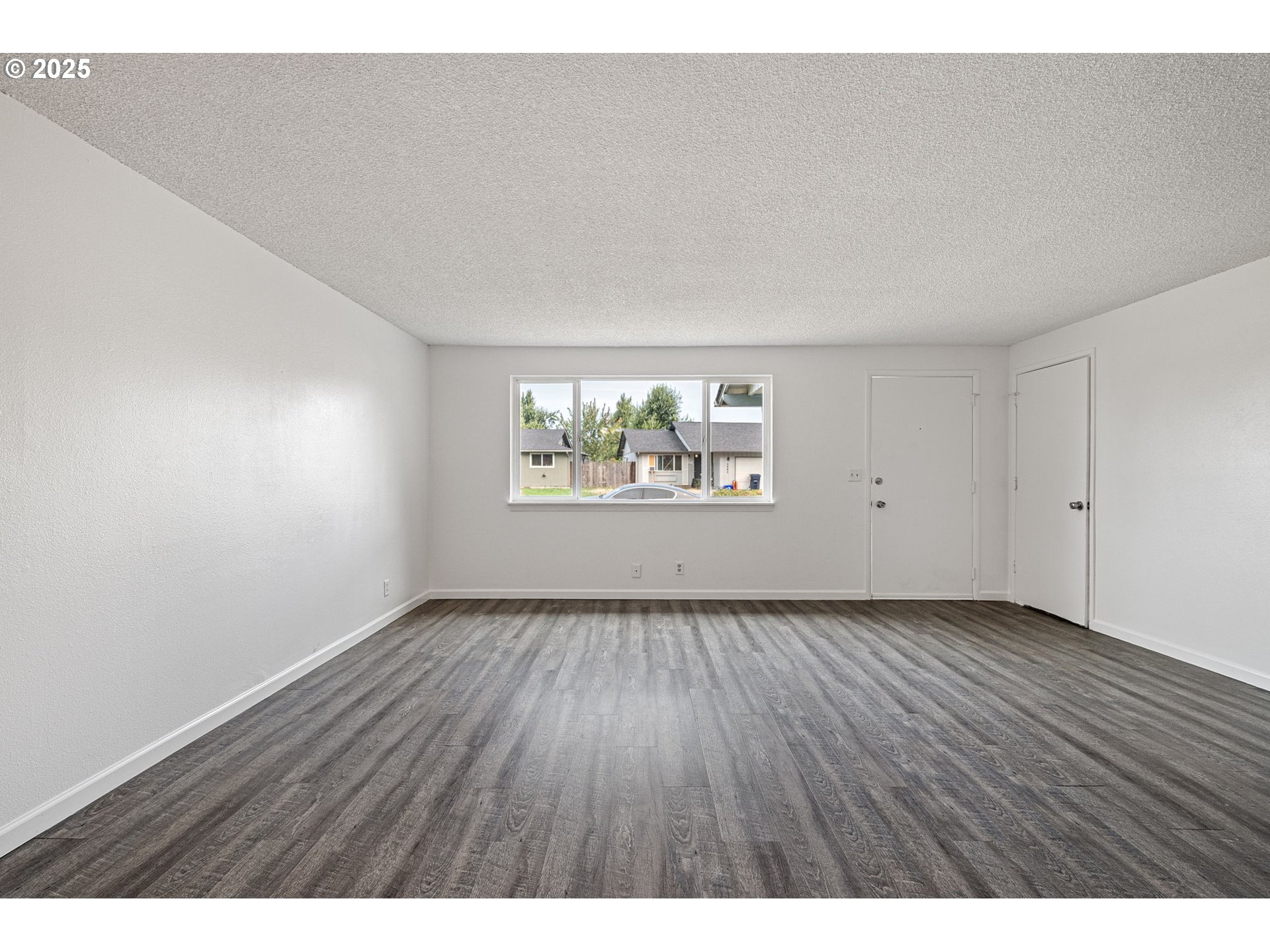 4883 Elderberry Loop Springfield, OR 97478 - Photo 4 of 23 a view of an empty room with a window and wooden floor
