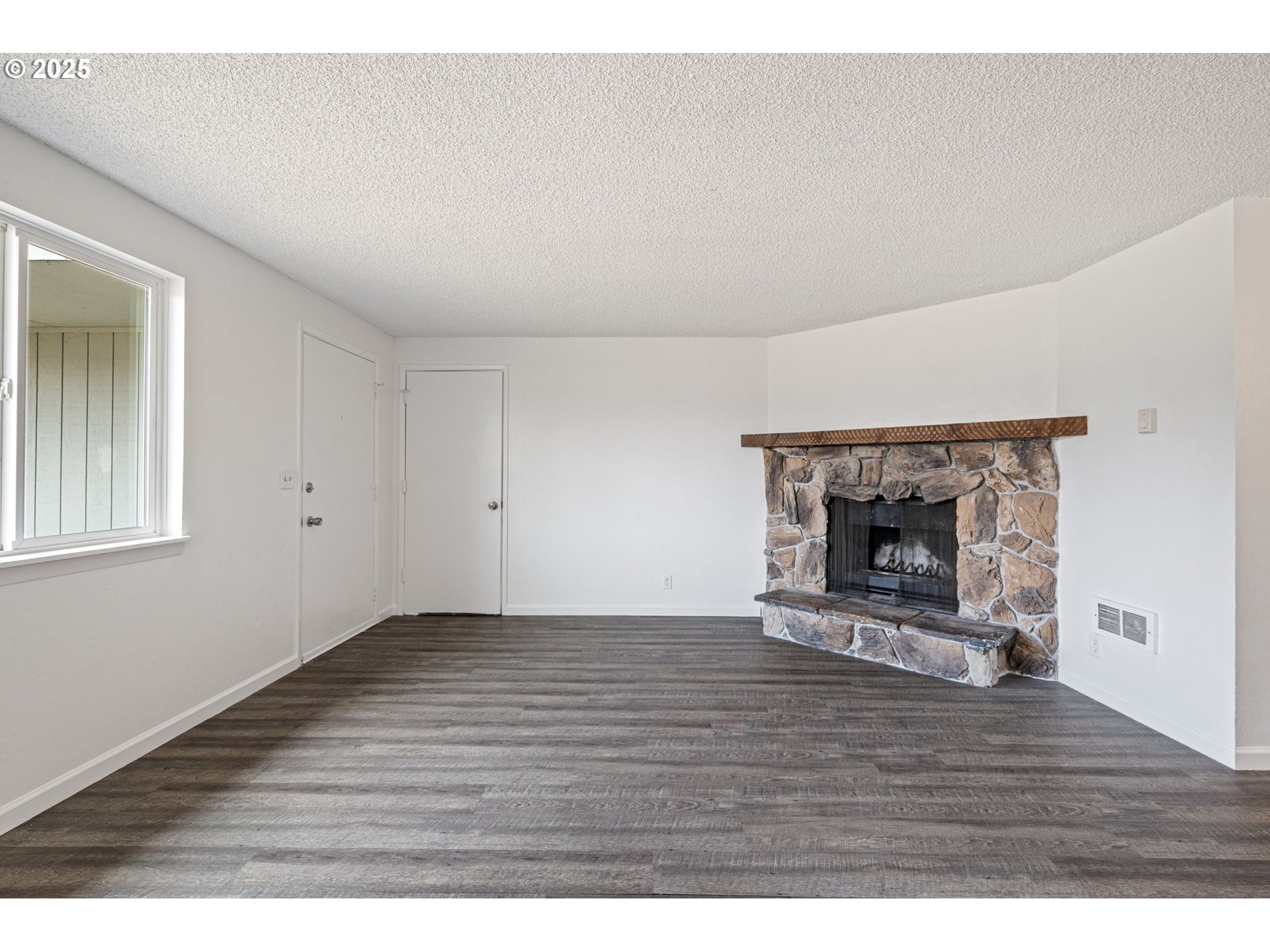 4883 Elderberry Loop Springfield, OR 97478 - Photo 5 of 23 a view of empty room with wooden floor and fireplace