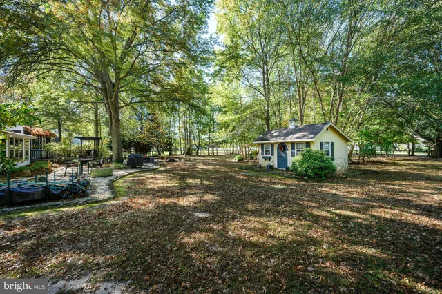 a living room with furniture a flat screen tv and a refrigerator