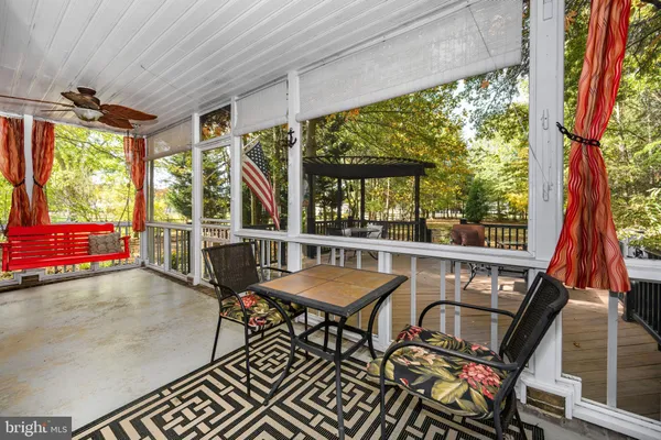 a living room with a black white checkered floor with a table and chair