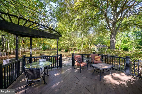 a view of a patio with a dining table and chairs with wooden floor