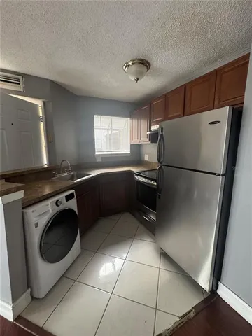a kitchen with a refrigerator sink and cabinets