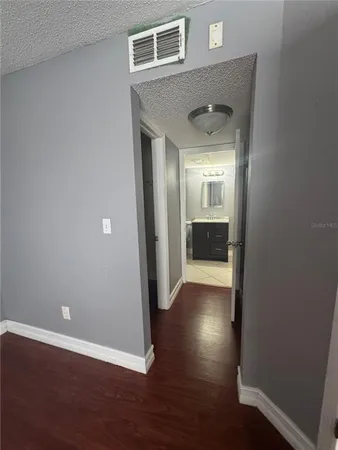 a view of a hallway with wooden floor and a living room
