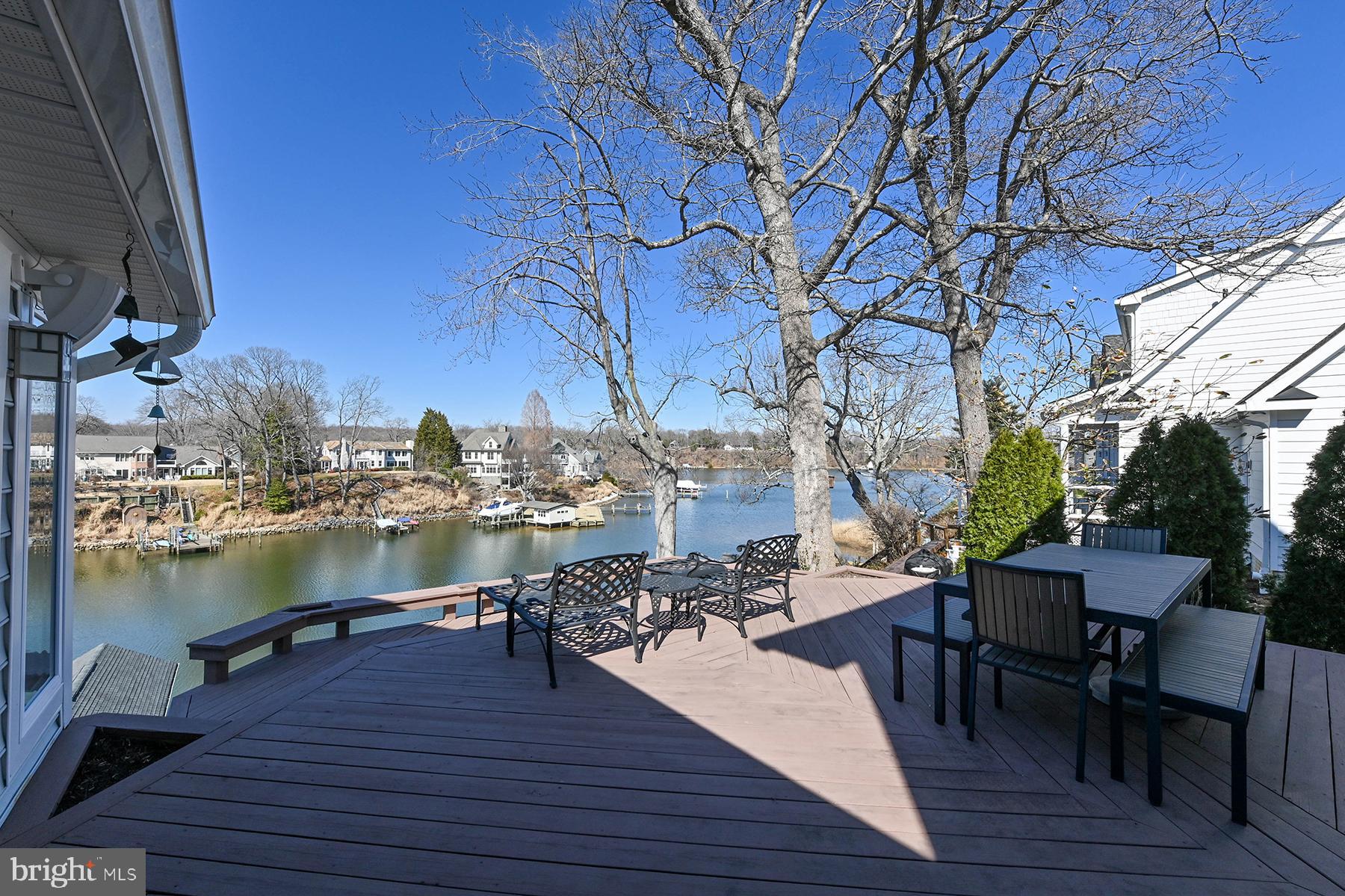 315 Cove Road Riva, MD 21140 - Photo 15 of 38 a view of a lake from a roof deck with table and chairs a barbeque with wooden floor and fence