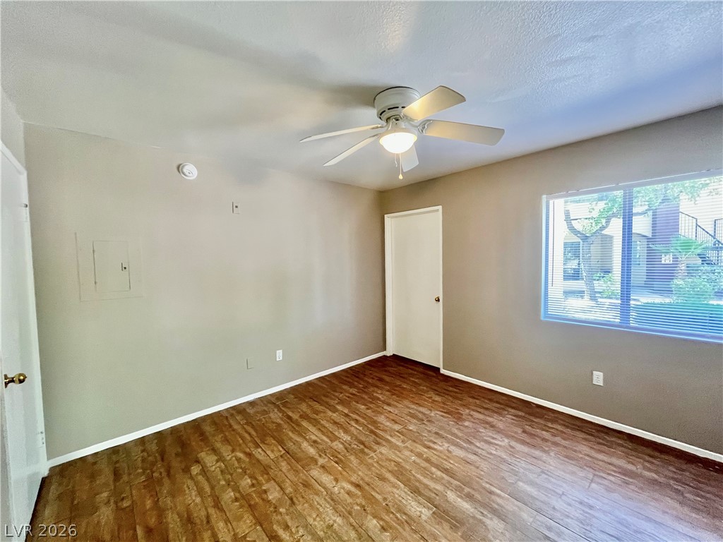 7885 West Flamingo Road, Unit 1029 Las Vegas, NV 89147 - Photo 14 of 18 Well-lit living area with rich wood flooring and a bright window.