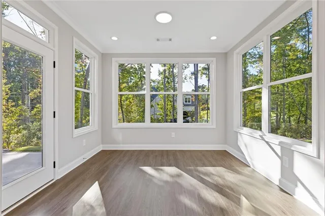an empty room with windows and ceiling fan