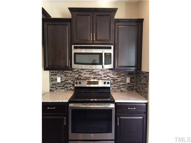 a kitchen with granite countertop a stove and a microwave