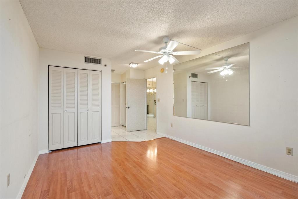 1200 St Charles Place, Unit PH7 Pembroke Pines, FL 33026 - Photo 19 of 28 a view of an empty room with wooden floor and a ceiling fan