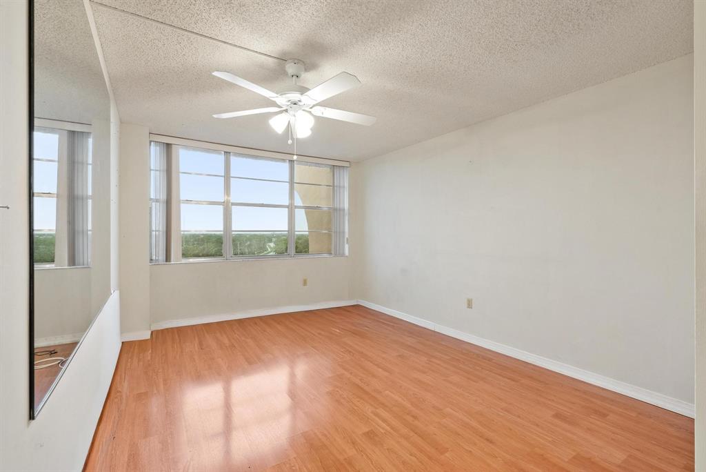 1200 St Charles Place, Unit PH7 Pembroke Pines, FL 33026 - Photo 20 of 28 a view of an empty room with wooden floor and a window