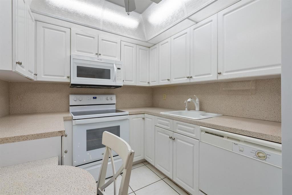 1200 St Charles Place, Unit PH7 Pembroke Pines, FL 33026 - Photo 8 of 28 a kitchen with white cabinets and white appliances