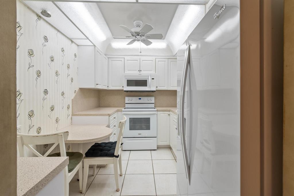 1200 St Charles Place, Unit PH7 Pembroke Pines, FL 33026 - Photo 9 of 28 a kitchen with cabinets and chairs