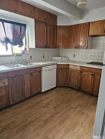 a kitchen with stainless steel appliances granite countertop wooden cabinets a sink and dishwasher with wooden floor
