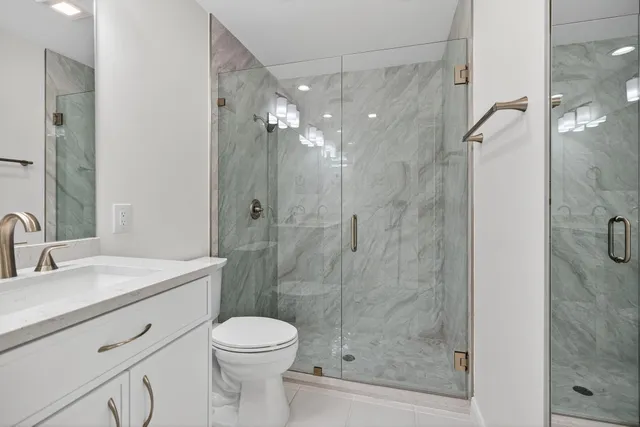 a bathroom with a sink a toilet and shower