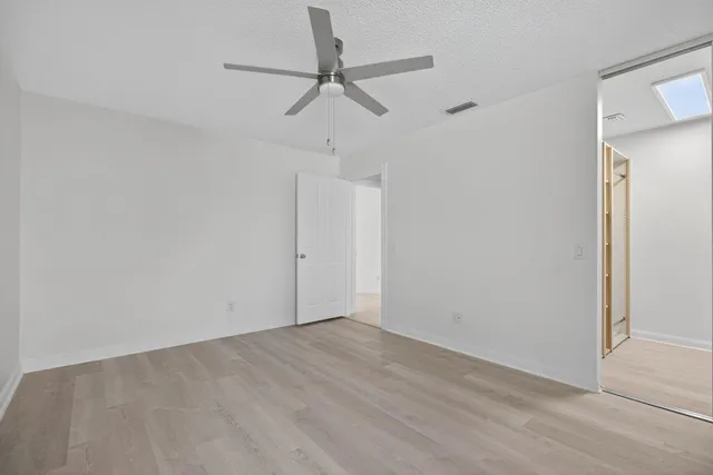 a view of a room with wooden floor closet and windows