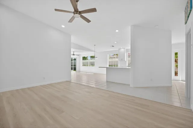 wooden floor in an empty room with a kitchen