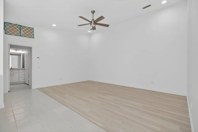 a view of kitchen with refrigerator and white cabinets