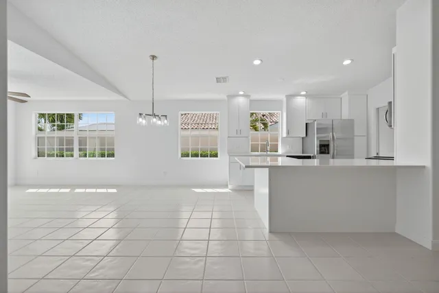a view of kitchen with windows and refrigerator