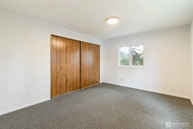an empty room with windows and closet