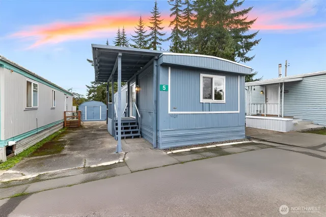 a view of a swimming pool with a yard and large trees