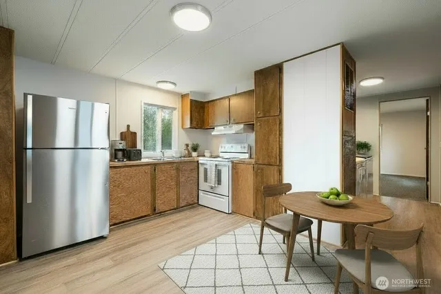 a kitchen with a refrigerator a table and chairs in it