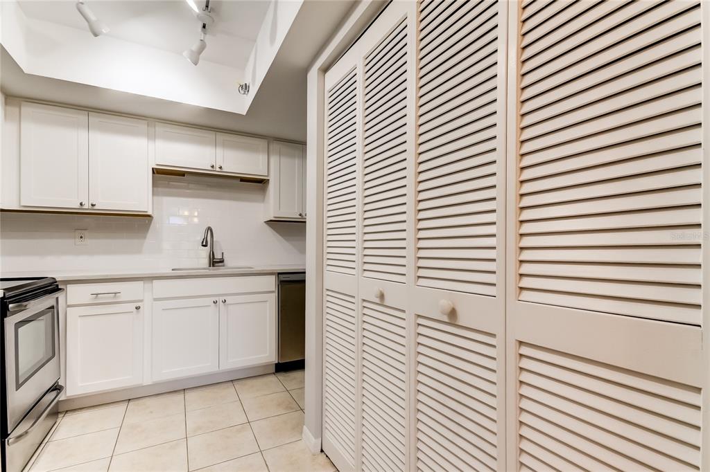 1801 East Lake Road South, Unit 12C Palm Harbor, FL 34685 - Photo 17 of 24 a kitchen with cabinets and white appliances