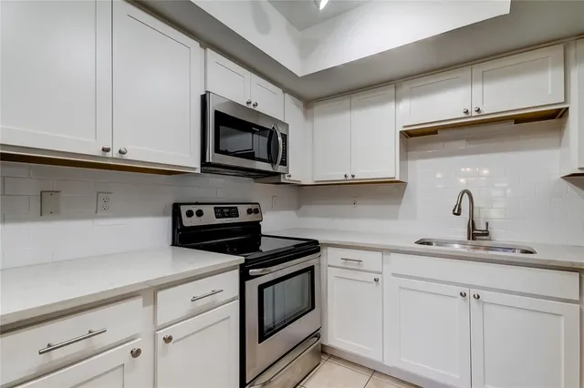a kitchen with white cabinets and white appliances
