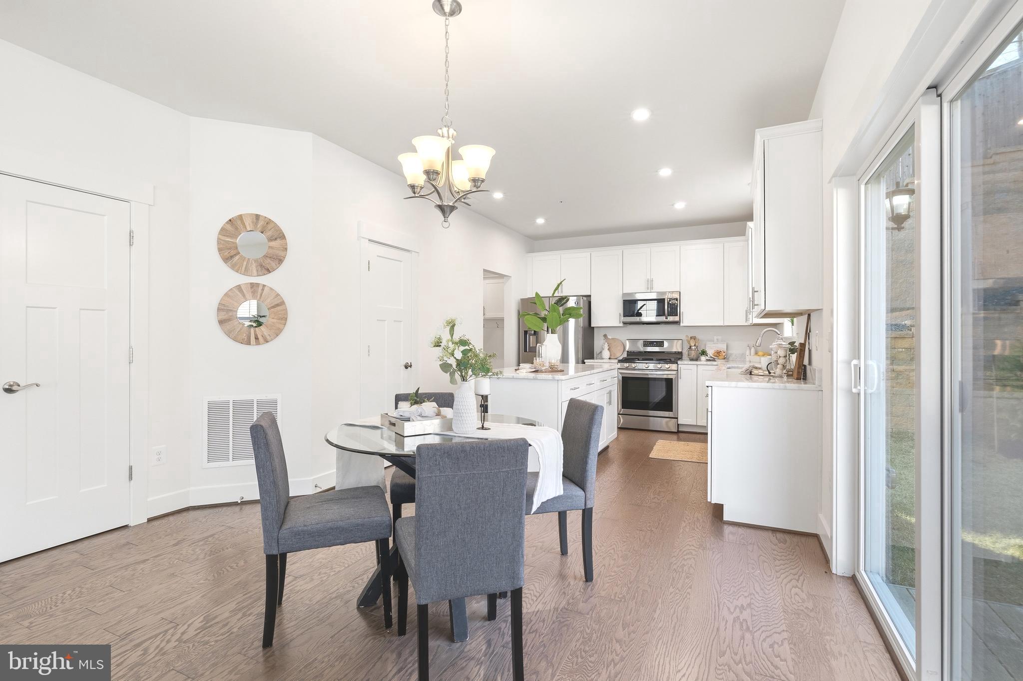 550 Broadneck Road Annapolis, MD 21409 - Photo 12 of 63 a view of a dining room with furniture a chandelier and wooden floor