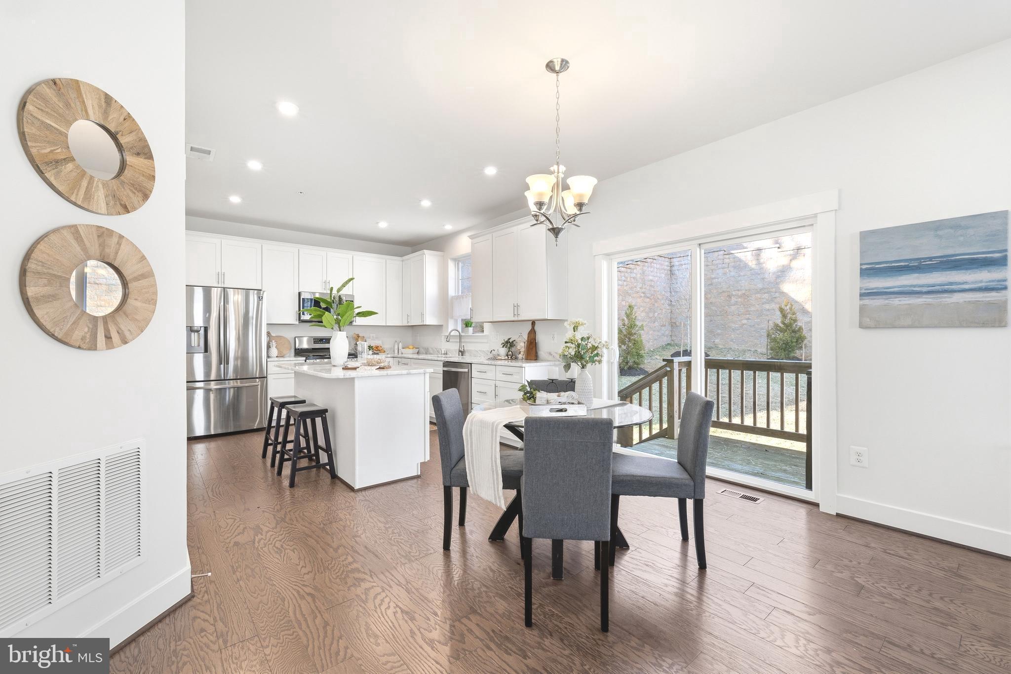 550 Broadneck Road Annapolis, MD 21409 - Photo 7 of 63 a dining room with wooden floor a chandelier a wooden table and chairs