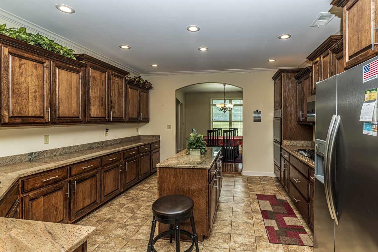 185 Belmont Road Mason, TN 38049 - Photo 3 of 40 a kitchen with stainless steel appliances granite countertop sink stove refrigerator and cabinets