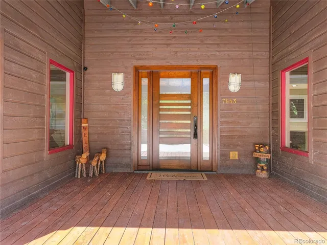 a view of front door with chair and wooden floor