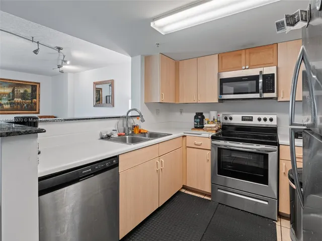 a kitchen with stainless steel appliances a stove sink microwave and cabinets