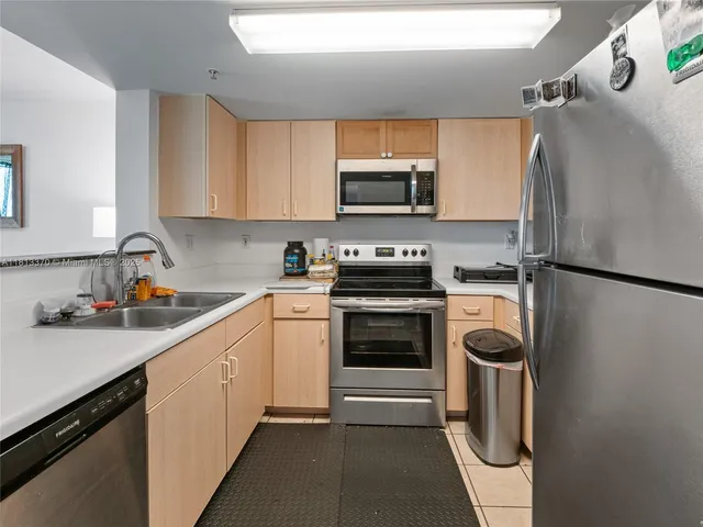 a kitchen with stainless steel appliances a refrigerator sink and microwave