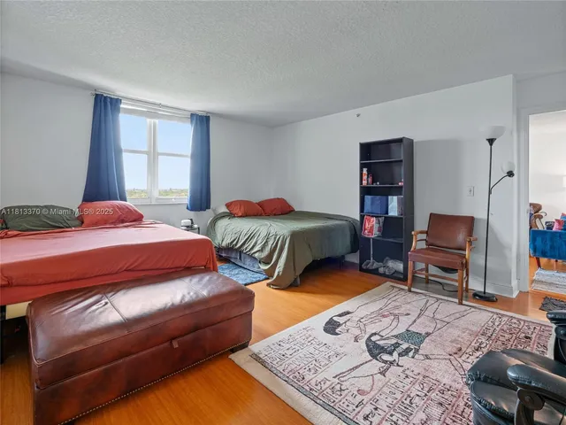 a bedroom with a bed dresser and a window