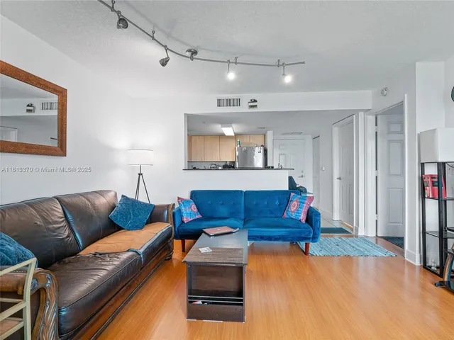 a bedroom with a bed couch and kitchen view